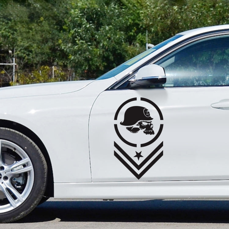 Skull-pattern emblem sticker close-up, black circular logo with helmeted skulls and chevrons
