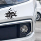 Black floral bloom car sticker on front bumper near headlight