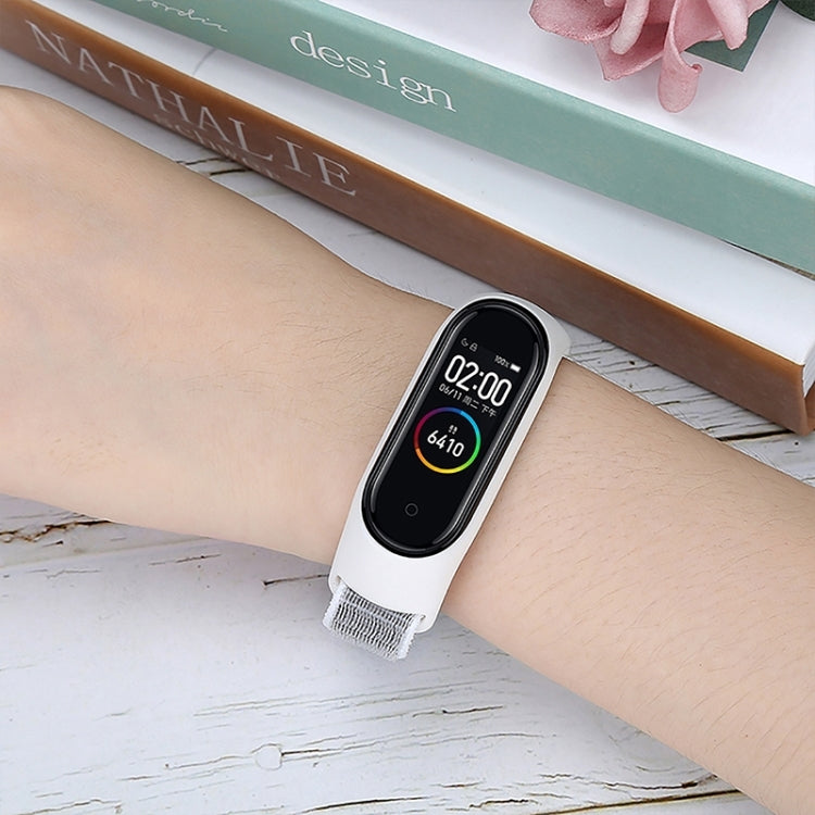 Nylon weave watch band on wrist, light gray strap with adjustable loop