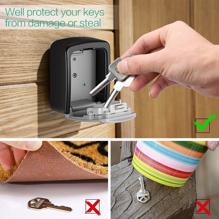 Black combination key box mounted on wooden wall, key inserted into the lock