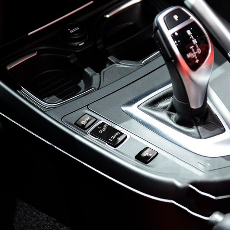 Black gear buttons on car center console near gear shifter, SPORT/ECOPRO/OFF/P icons