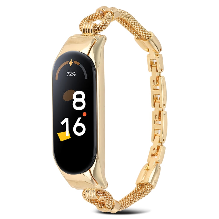 Gold metal watch band with mesh links and rectangular smartwatch tracker, front view.