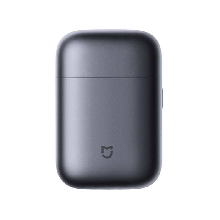 Electric shaver with dark gray rounded body and small power symbol on the front