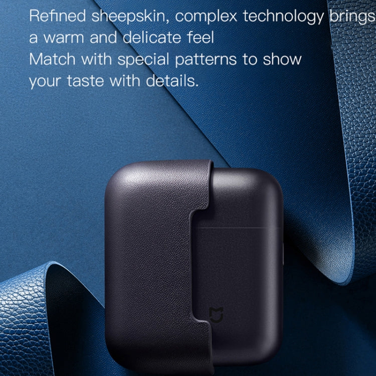 Electric shaver beside dark leather-look protective sleeve