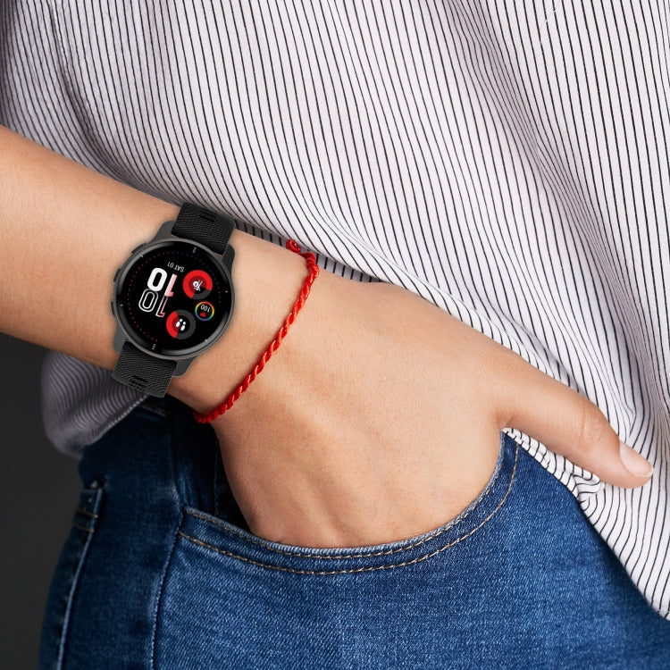Black cross-textured silicone smartwatch band on wrist with metal clasp