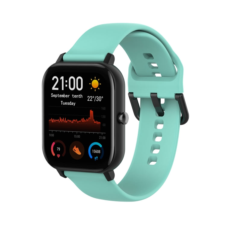 Turquoise soft silicone smartwatch band with adjustable holes and clasp.