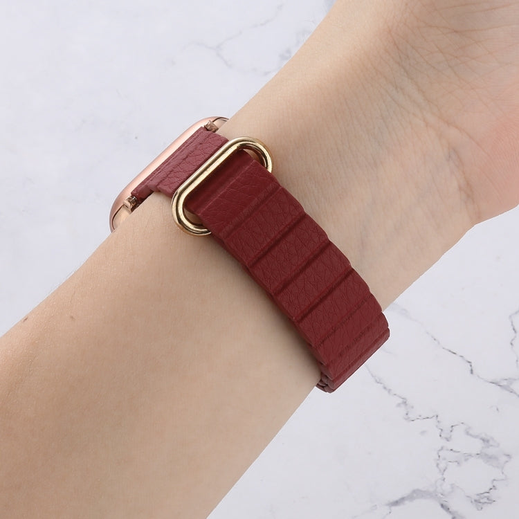 Maroon leather-look magnetic watch band with rose-gold loop clasp on wrist