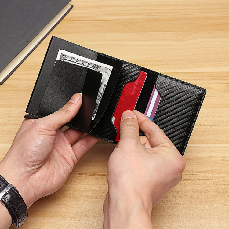Black carbon fiber RFID wallet with cash compartment as hands load cards