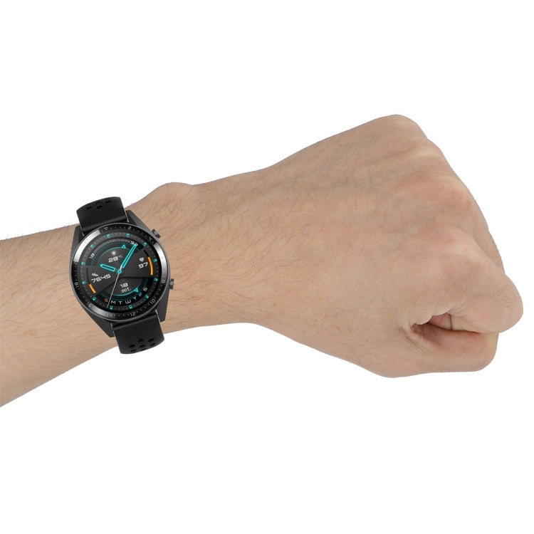Black perforated sport watch strap on wrist with metal buckle clasp