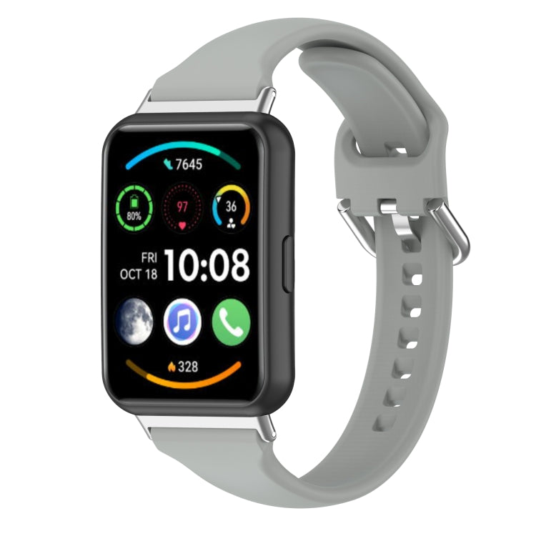 Grey silicone watch band with metal buckle and multiple adjustment holes.