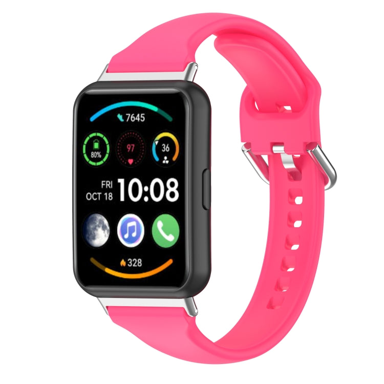 Hot pink silicone watch band with metal clasp and adjustment holes (side view).