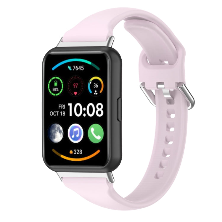 Silicone smartwatch band with metal buckle, pale pink strap and perforated holes.