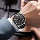 Men's quartz leather watch on wrist, black dial and black leather strap, round case