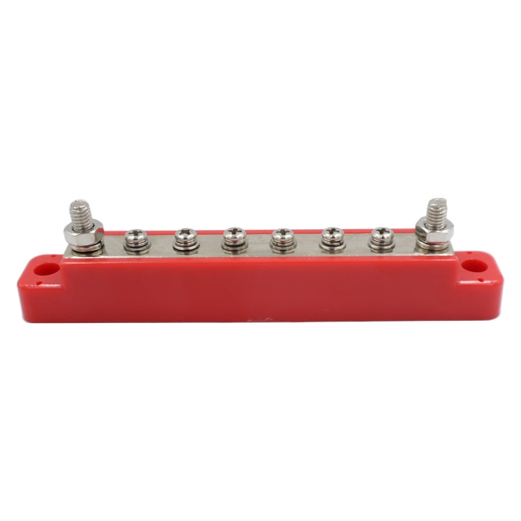 Red terminal block with row of stud posts for power distribution and wiring