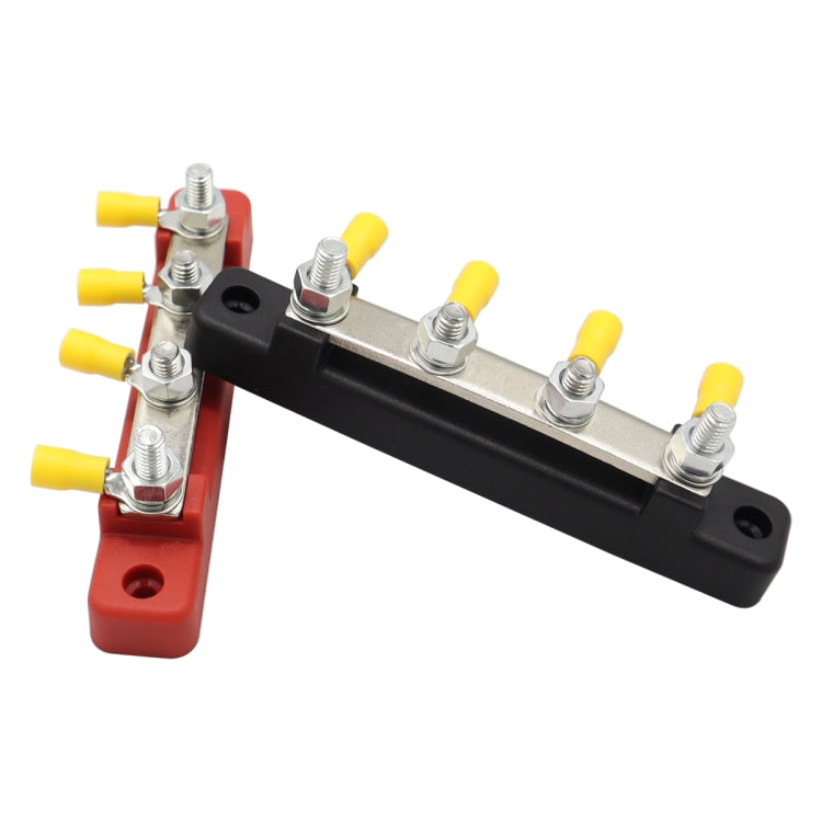 Angled view of busbar terminal block with red and black housings, silver studs, and yellow connectors