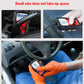 Compact OBD2 scanner being connected in a car interior, red/black handheld unit