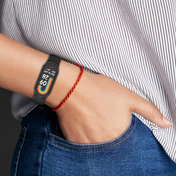 Smartwatch strap on wrist with red braided bracelet and oval display