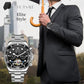 Two-tone stainless-steel mechanical watch with black dial and gold hands on wrist