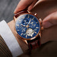 Blue dial mechanical watch on wrist with brown leather strap and rose-gold case