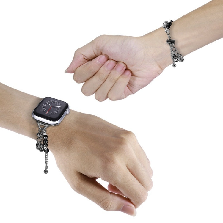 Pearl watch band bracelet with black beads and silver chain on wrist, small hanging charm
