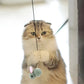 Retractable cat teaser stick with green-blue mouse plush hanging in front of cat