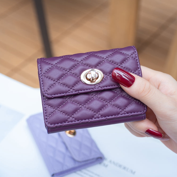 Purple quilted card bag with metal buckle clasp held in hand