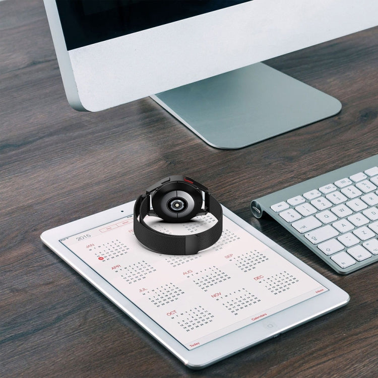 Black magnetic metal mesh watch band on a smartwatch, resting on a desk