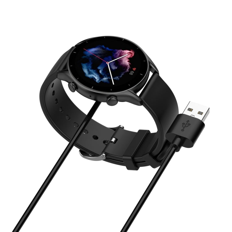 Black magnetic charging cable connected to a smartwatch with a round display