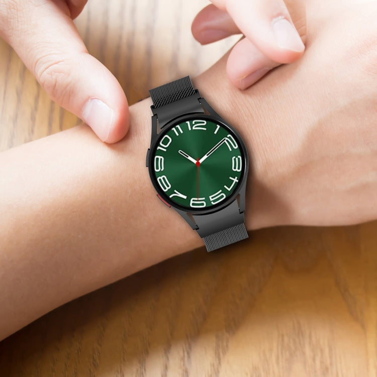 Magnetic metal watch band on wrist, black mesh strap on round smartwatch