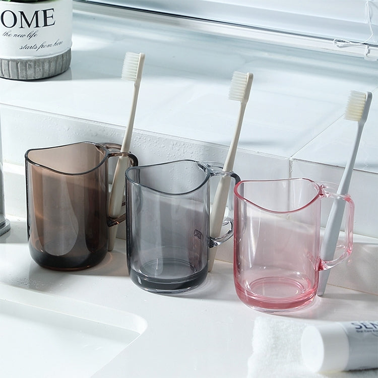 Clear acrylic mouthwash cup set with toothbrush bristles in handle slots