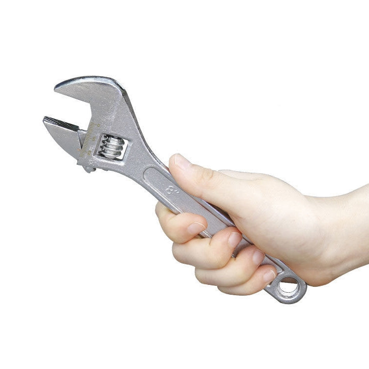 Chrome adjustable wrench held in hand, open jaw with knurled adjustment screw