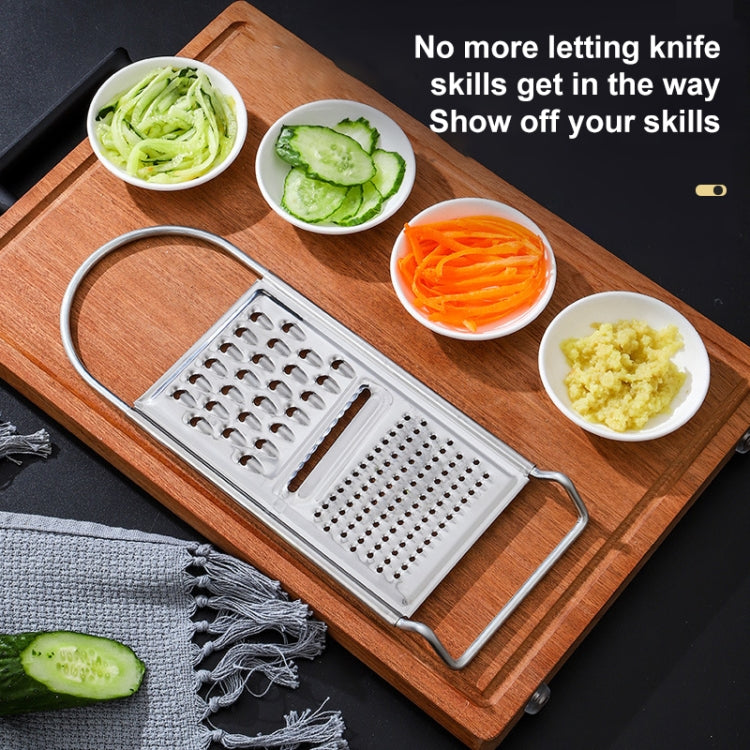 Stainless steel vegetable grater with fine and coarse sides on a wooden board