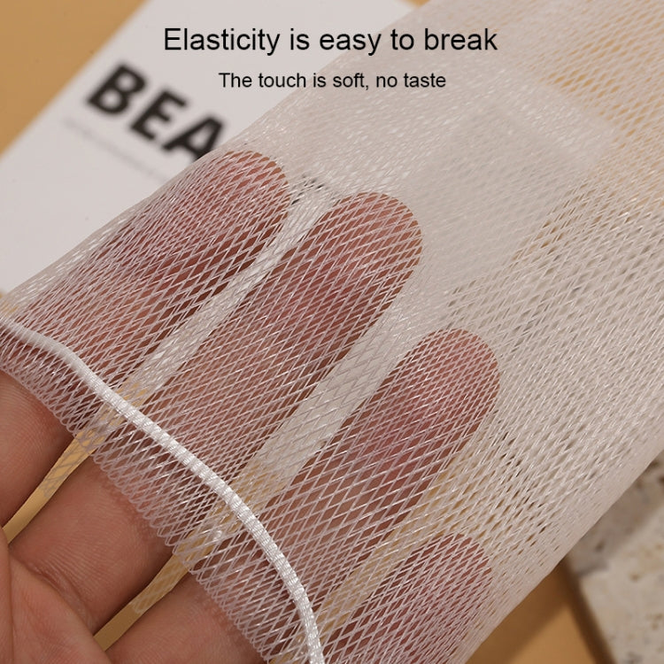 Hand holding a fine mesh foaming net pouch, pale beige color