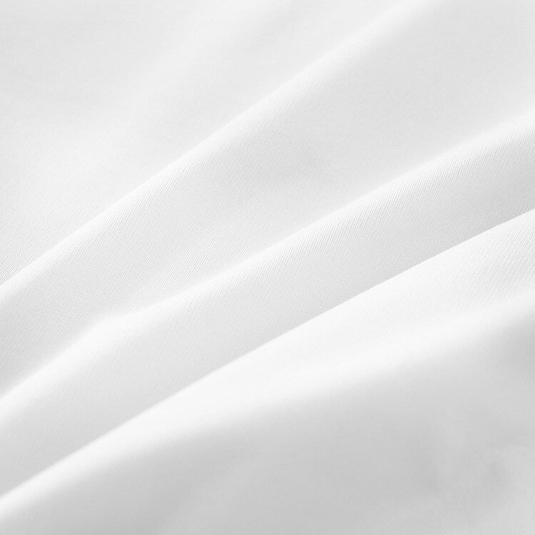 White knitted fabric pillowcase material close-up, smooth woven texture