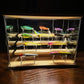 Glass-front clear lure display case with multiple transparent stand bases and hooks
