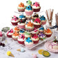 Clear 3-tier acrylic cupcake stand with multiple cupcakes and colorful toppers
