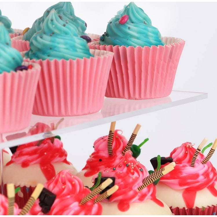 Cupcakes on a clear 4-tier cupcake stand with teal frosting and pink liners
