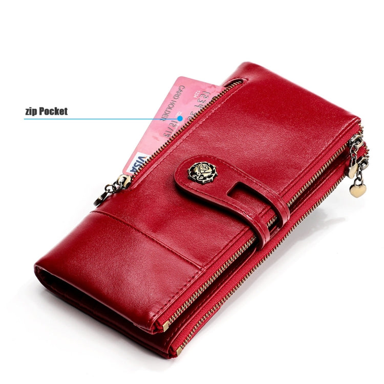 Red leather wallet with side zip pocket and front strap detail, shown at an angle.