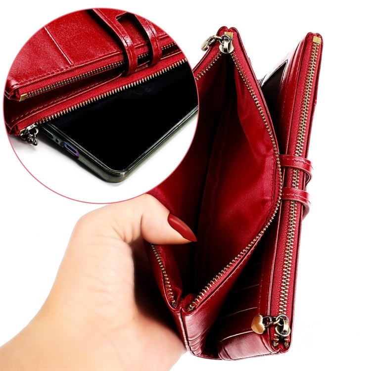 Red leather wallet open with zip track and card pocket lining, handheld close-up view.