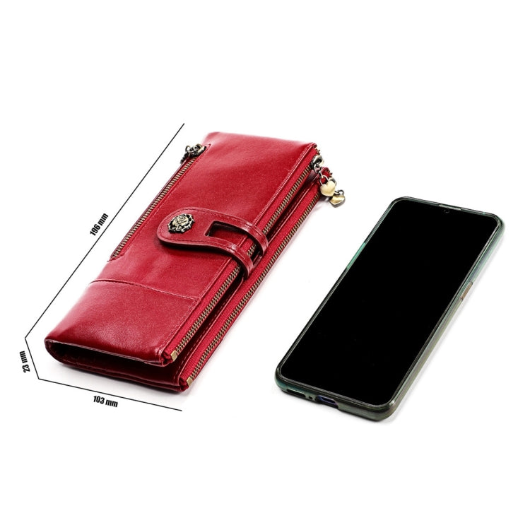 Red leather wallet with side zip and strap closure, shown next to a smartphone.