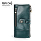 Dark teal leather lady wallet with front strap, decorative badge, and zip pocket detail.