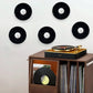 Wall-mounted clear acrylic record display stand holding vinyl records on wall