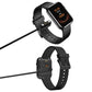 Black magnetic charging cable attached to a smartwatch at its charging contacts