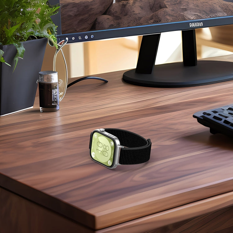 Black nylon hook-and-loop watch band fitted to a smartwatch on a desk