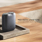 Compact dark grey electric shaver standing with two round foil heads on a base