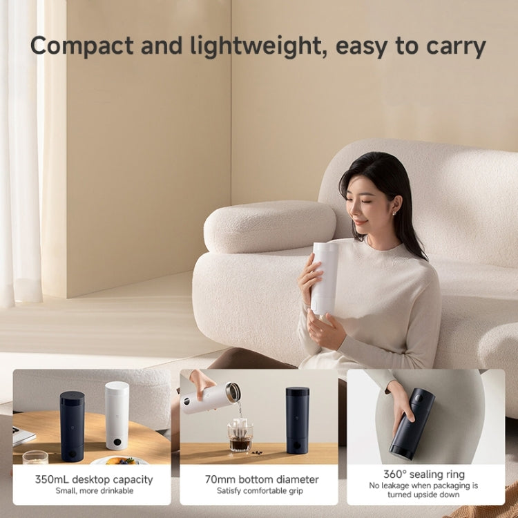 Portable electric heating cup on a table with compact, grip-friendly design