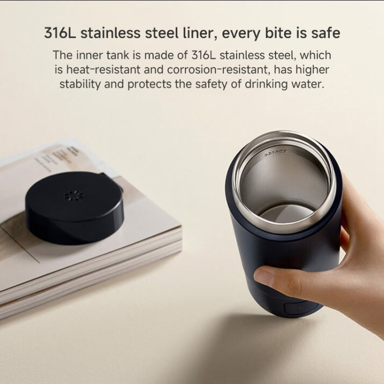 Handheld portable electric heating cup showing stainless inner liner through cutaway