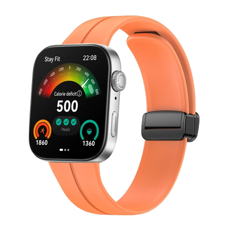 Orange silicone watch band with black magnetic buckle shown on a smartwatch