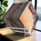 Acrylic record display stand close-up with stacked vinyl records in transparent frame