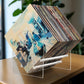 Acrylic vinyl record display stand holding stacked records with clear side supports